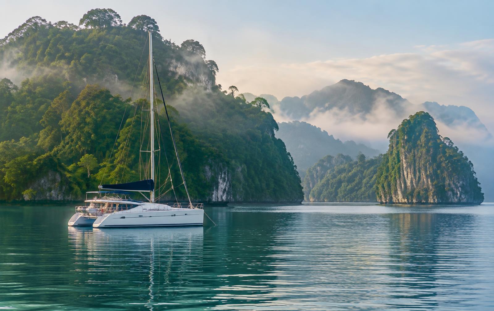 Catamaran at anchor among the misty rainforest islands of Langkawi, Malaysia